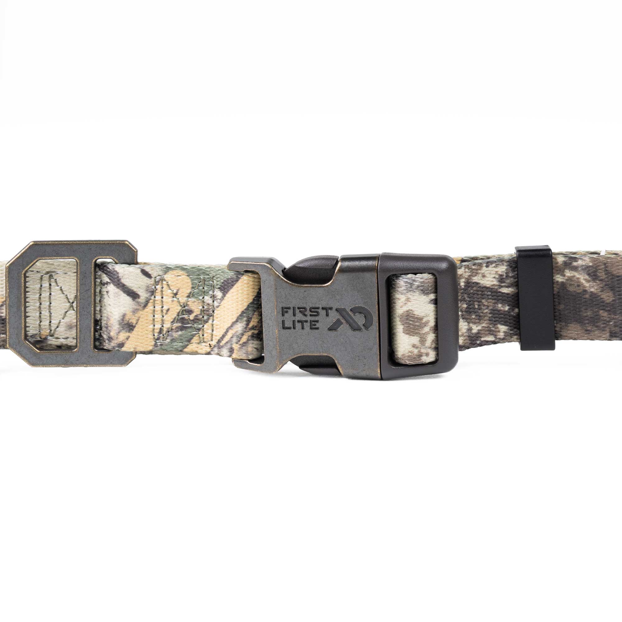 A close-up of a camouflage dog collar with a dark gray metal quick-release buckle. The collar features a woodland camo pattern in shades of green, brown, and beige, with the brand name 'FIRST LITE' clearly visible on the buckle.