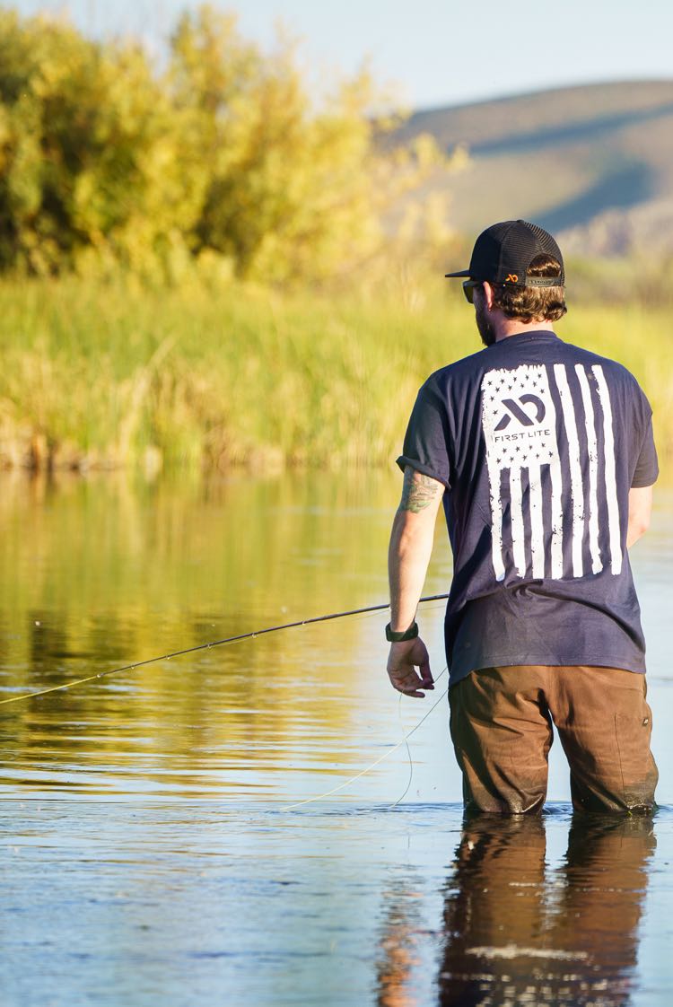Man fishing wearing First Lite American Flag design t-shirt