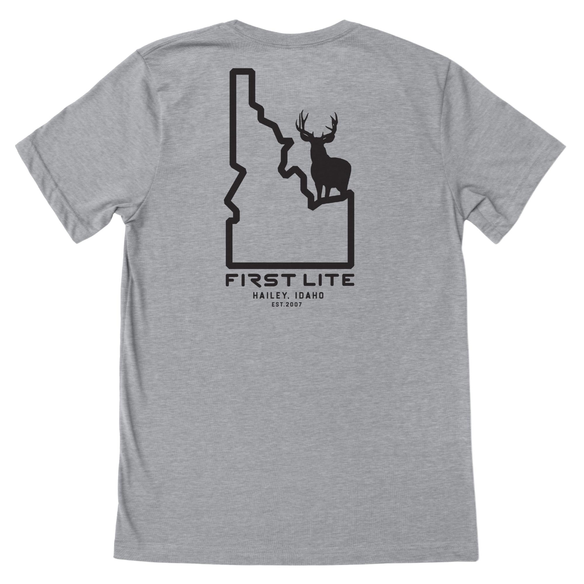 Light gray t-shirt with a black graphic on the back showing an Idaho state outline with a deer silhouette inside and text "FIRST LITE HAILEY, IDAHO EST.2007"