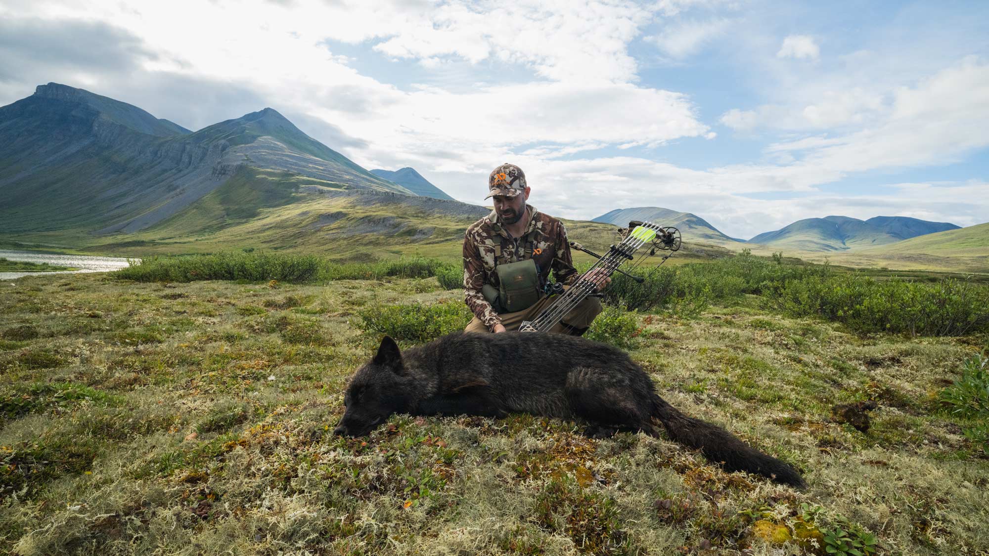 Remi Warren with a black wolf in Alaska.