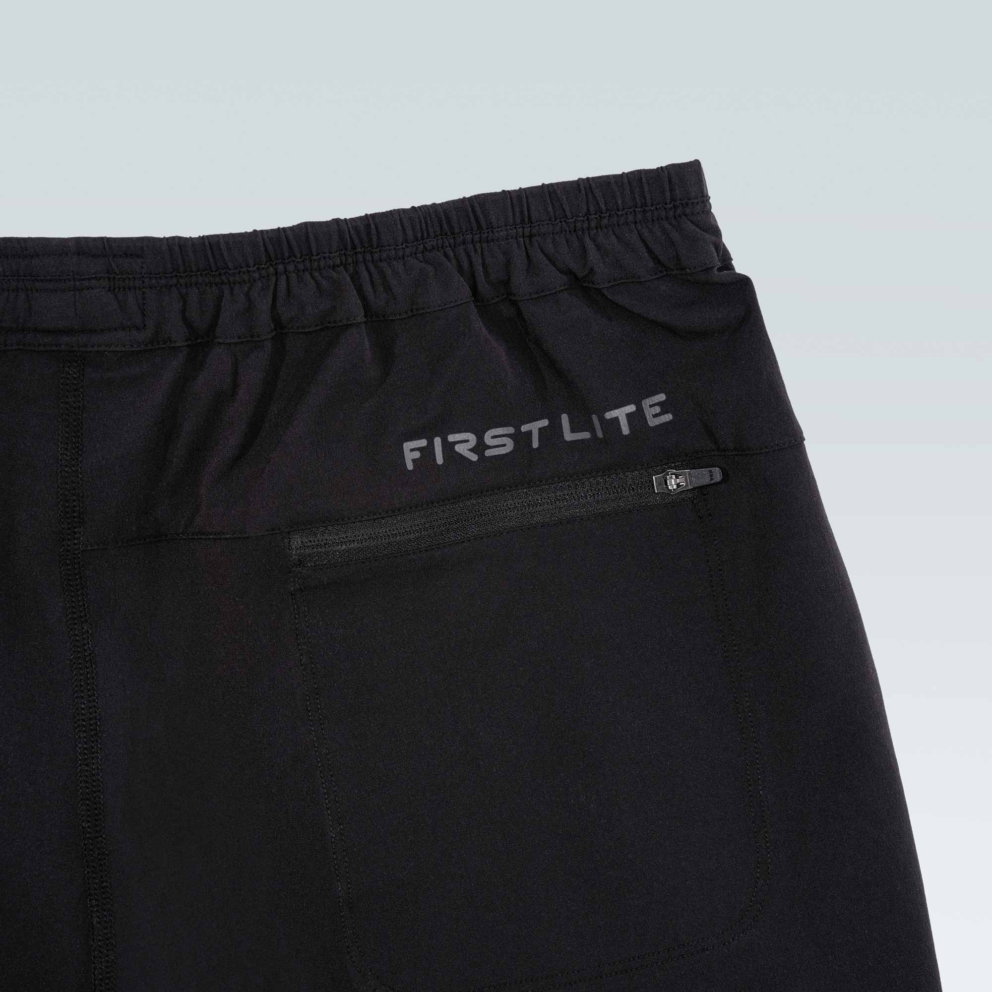 Black pants with 'First Lite' branding on a light gray background