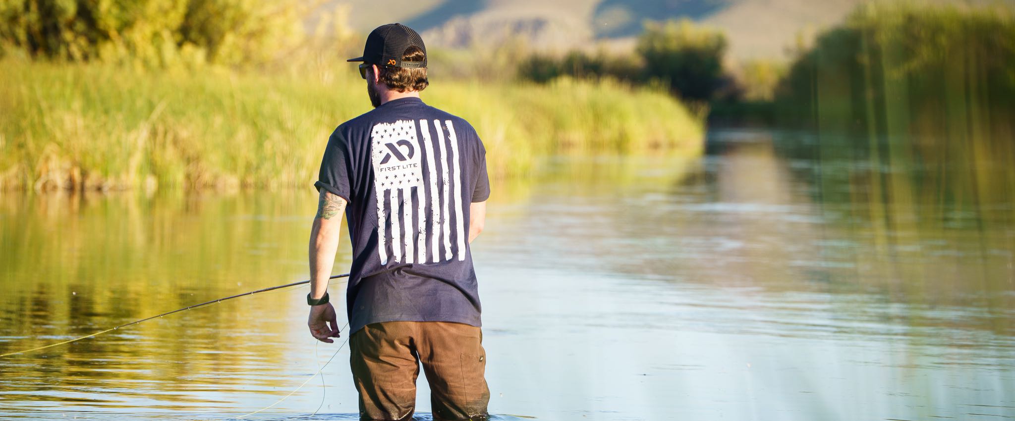 Man fishing wearing First Lite American Flag design t-shirt