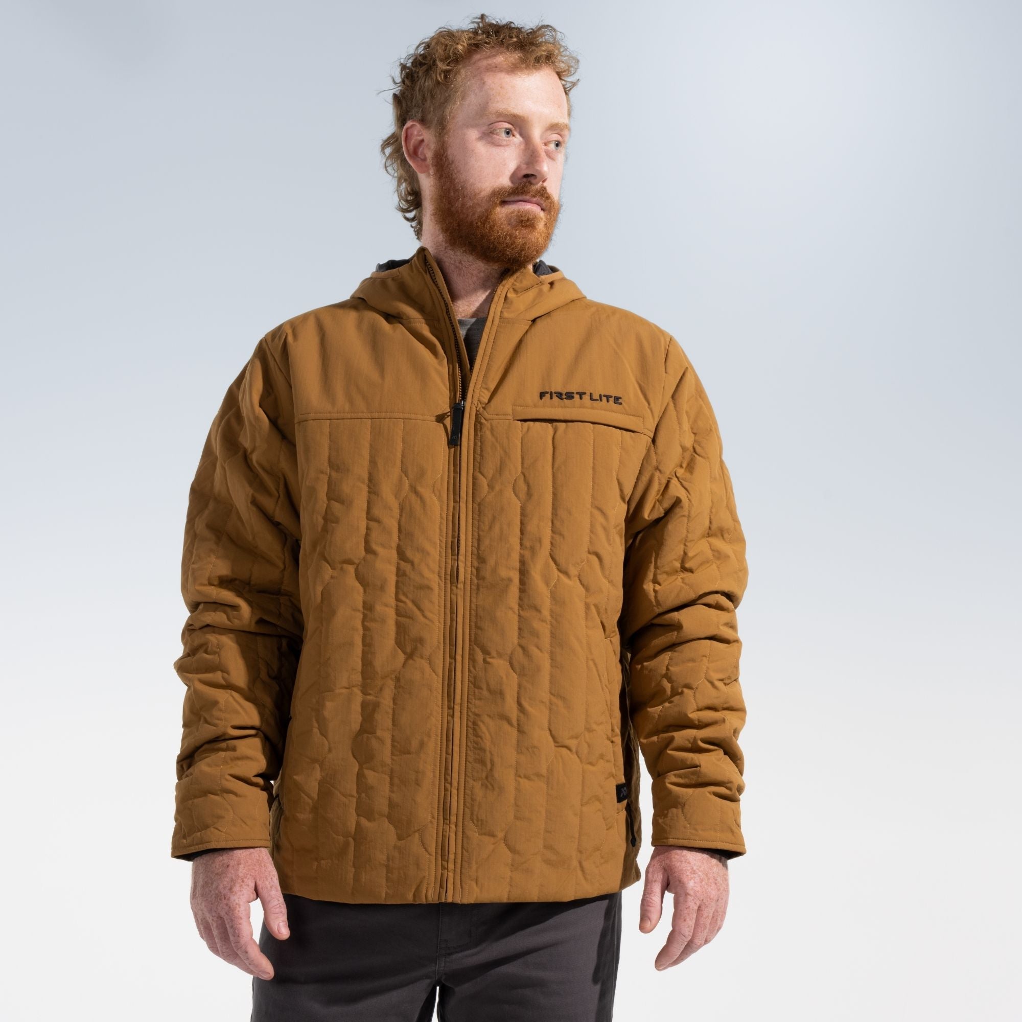 Man wearing a rust outopost jacket and dark gray pants.