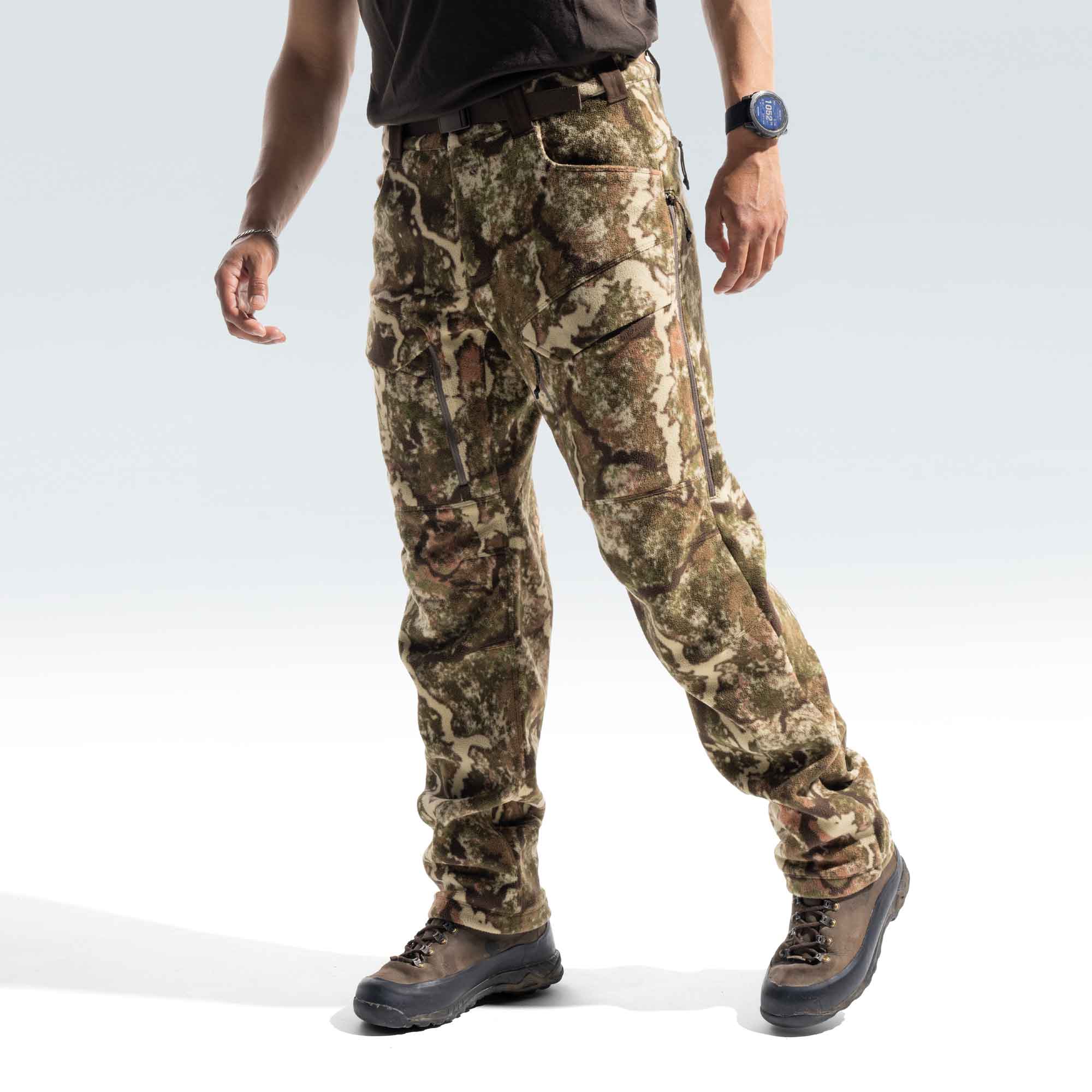 Bottom shot of a man wearing a brown shirt, camo pants and brown boots.