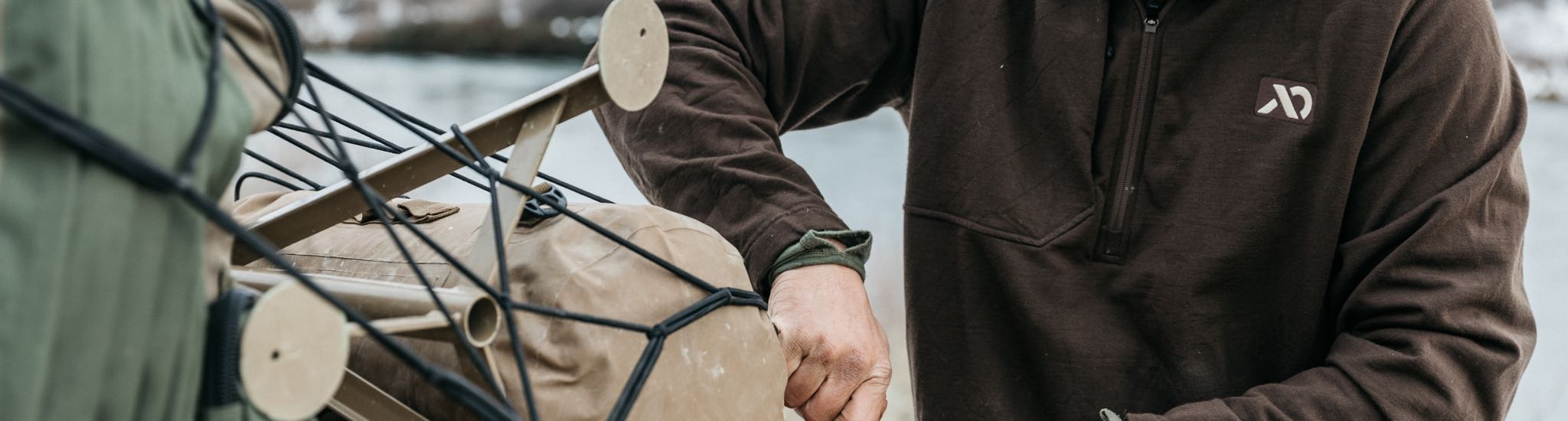 Dark brown quarter-zip sweatshirt with chest logo and front pocket.