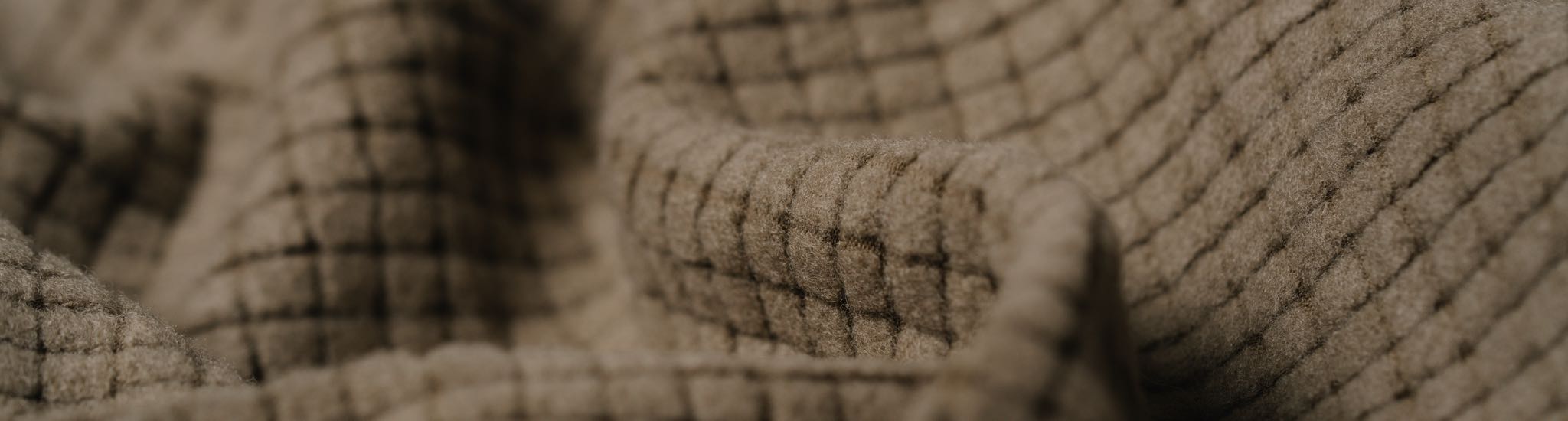 Fuzzy tan fabric with a waffle-knit pattern, close-up.
